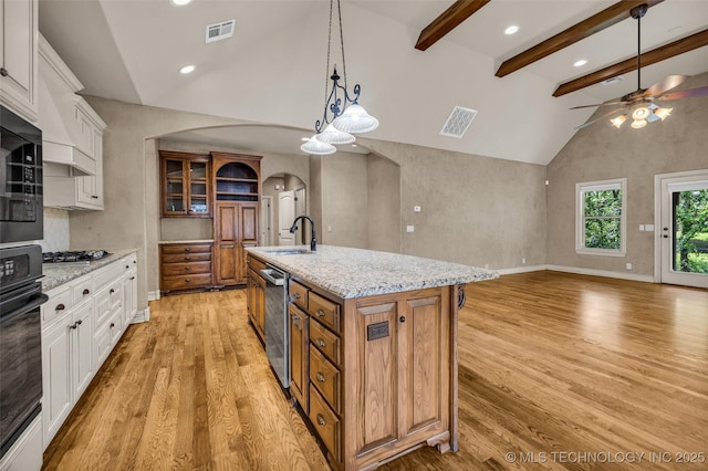 kitchen featuring visible vents, arched walkways, a ceiling fan, and stainless steel appliances