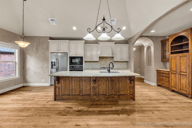 kitchen featuring white cabinets, visible vents, light wood finished floors, and black appliances