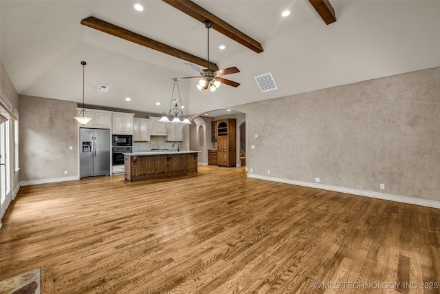 kitchen featuring vaulted ceiling with beams, open floor plan, and black appliances