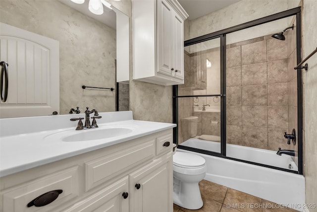 bathroom featuring tile patterned floors, bath / shower combo with glass door, vanity, and toilet