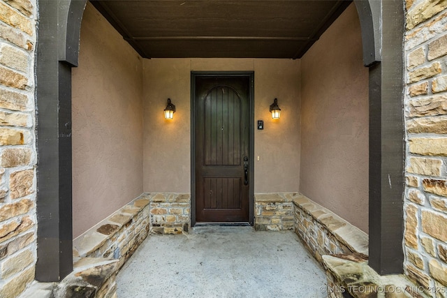 entrance to property with stucco siding and stone siding