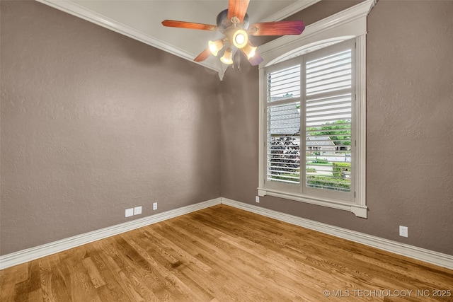 spare room with baseboards, a ceiling fan, and wood finished floors