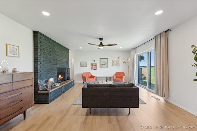 7207 E 166th St, Collinsville, OK 74021 - living area featuring a fireplace, light wood-style floors, ceiling fan, recessed lighting, and baseboards