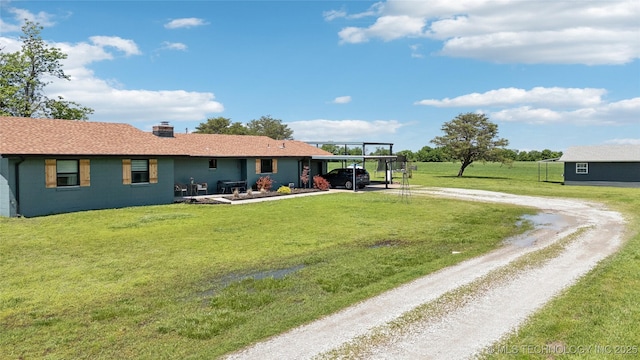 7207 E 166th St, Collinsville, OK 74021 - rear view of house with dirt driveway, a carport, concrete block siding, a yard, and a chimney