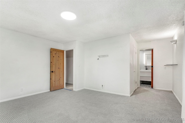 unfurnished room with baseboards, carpet flooring, and a textured ceiling