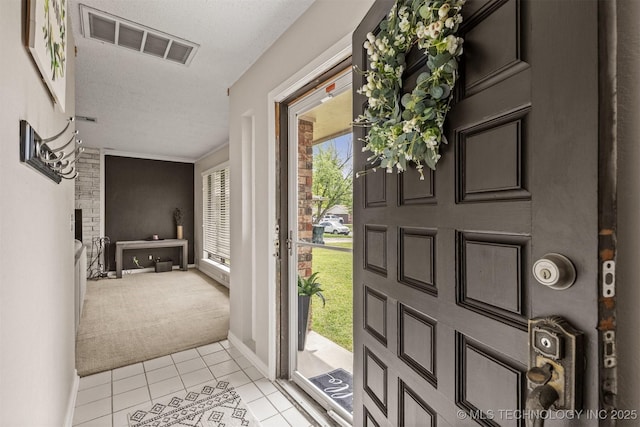 entrance foyer featuring visible vents, plenty of natural light, light tile patterned floors, and light colored carpet