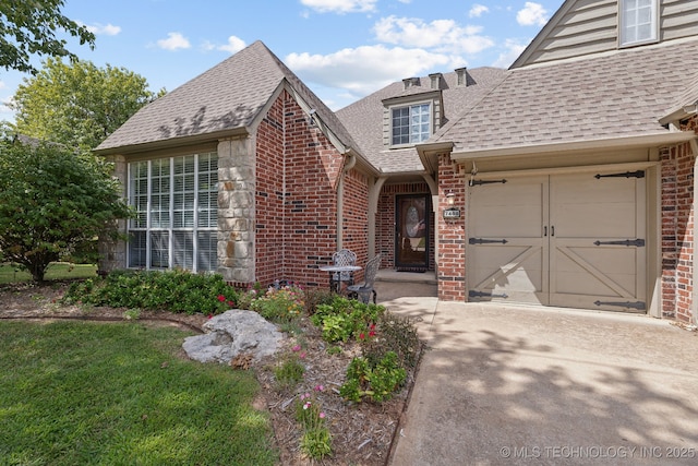 7408 E Forest Ridge Blvd, Broken Arrow, OK 74014 - view of exterior entry with brick siding, driveway, a shingled roof, and a garage