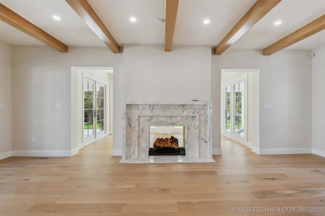 unfurnished living room with plenty of natural light, baseboards, and wood finished floors