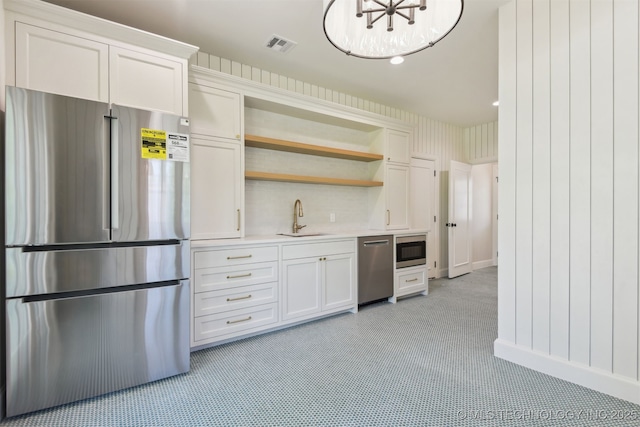 kitchen with visible vents, open shelves, light countertops, a sink, and appliances with stainless steel finishes
