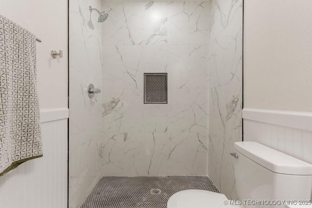 full bathroom with a marble finish shower and toilet