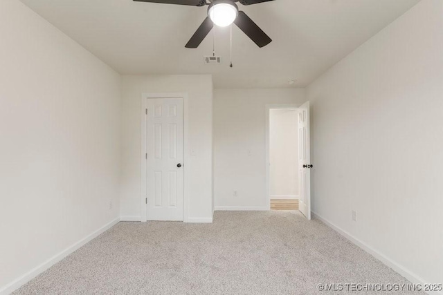 unfurnished bedroom featuring baseboards, visible vents, ceiling fan, and carpet