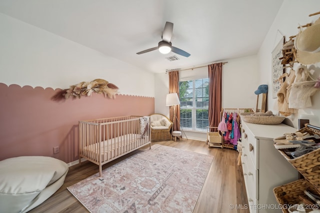 309 E 125th Ct S, Jenks, OK 74037 - bedroom featuring light wood-style floors, a nursery area, ceiling fan, and visible vents