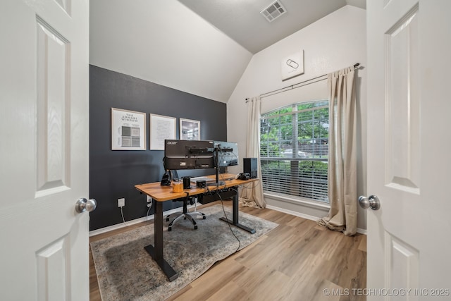 home office featuring baseboards, visible vents, wood finished floors, and lofted ceiling