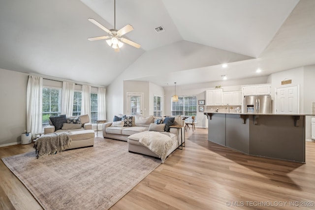 living area featuring light wood finished floors, high vaulted ceiling, a ceiling fan, recessed lighting, and visible vents