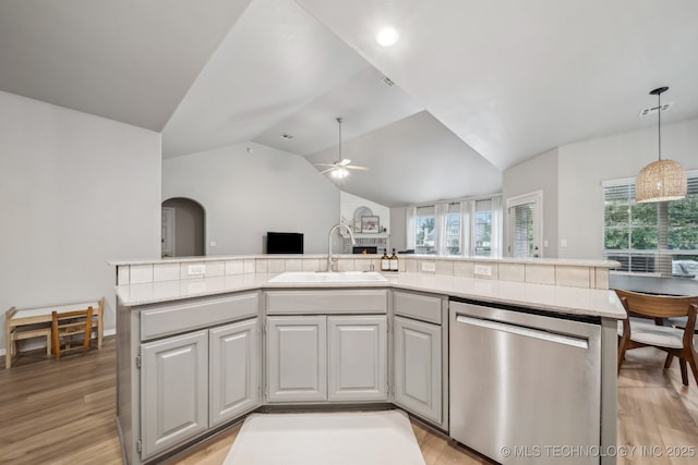 kitchen with light countertops, light wood-style floors, a sink, and dishwasher