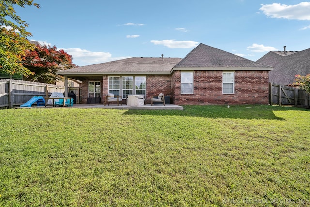 309 E 125th Ct S, Jenks, OK 74037 - rear view of house with roof with shingles, brick siding, a fenced backyard, a patio area, and a lawn