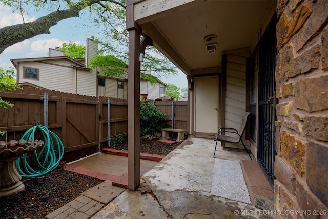 view of patio featuring fence and a gate
