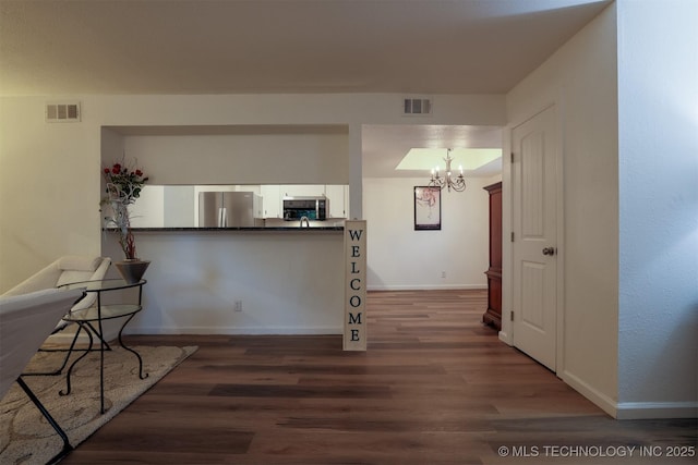 interior space with white cabinetry, appliances with stainless steel finishes, an inviting chandelier, and visible vents