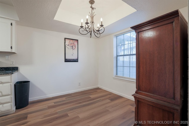 6371 S 80th Ave E Unit G, Tulsa, OK 74133 - unfurnished dining area with a chandelier, light wood finished floors, baseboards, a raised ceiling, and a textured ceiling