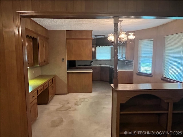 3316 Maple Dr, Sand Springs, OK 74063 - kitchen featuring brown cabinets, a chandelier, light countertops, and light carpet