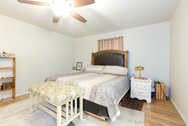 bedroom with baseboards, ceiling fan, and wood finished floors