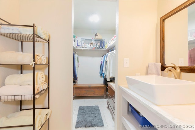 walk in closet with a sink and tile patterned floors