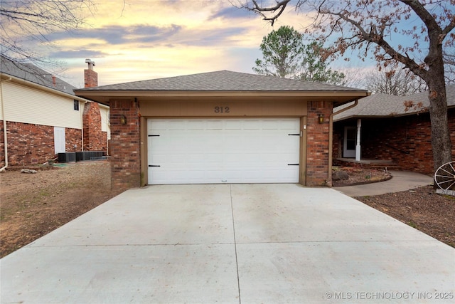 view of property exterior featuring roof with shingles, brick siding, concrete driveway, an attached garage, and central air condition unit