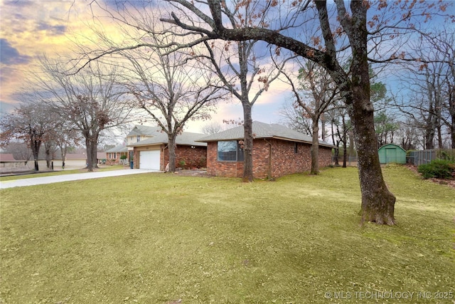 view of front of home with fence, brick siding, a garage, concrete driveway, and a yard