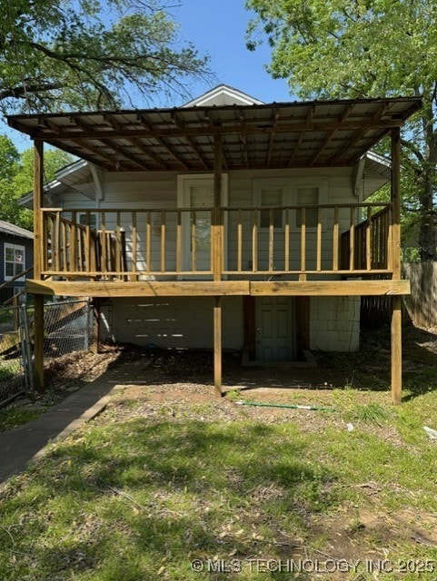 rear view of house featuring fence