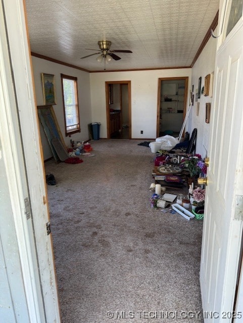 interior space featuring carpet floors, a ceiling fan, and ornamental molding