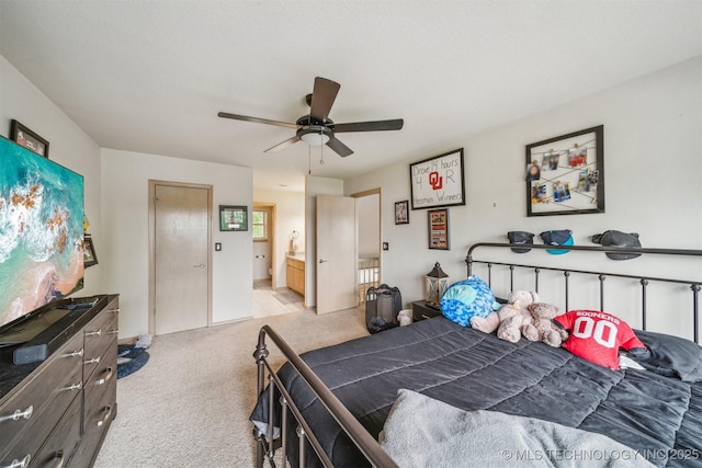 bedroom with a ceiling fan, connected bathroom, and light carpet