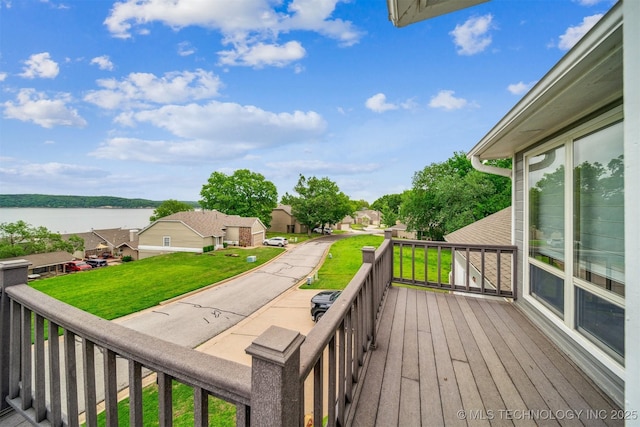 wooden terrace featuring a water view and a yard
