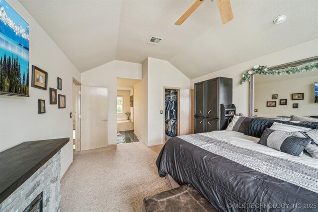 bedroom with visible vents, vaulted ceiling, a closet, a spacious closet, and light carpet