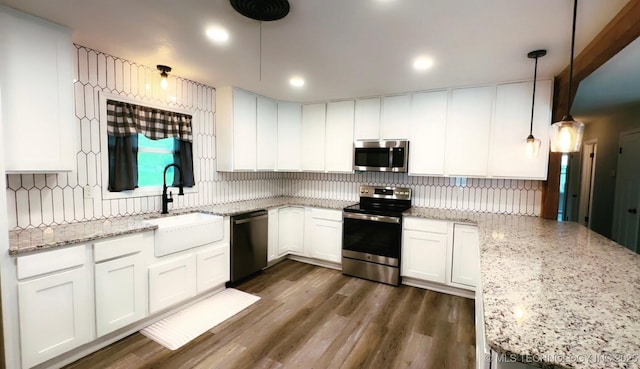 kitchen featuring white cabinetry, appliances with stainless steel finishes, a sink, and tasteful backsplash