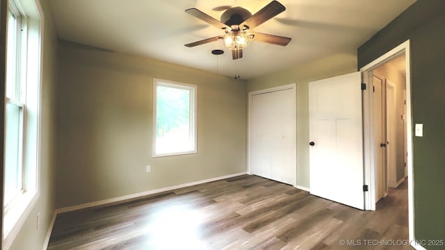 unfurnished bedroom with a closet, baseboards, and wood finished floors