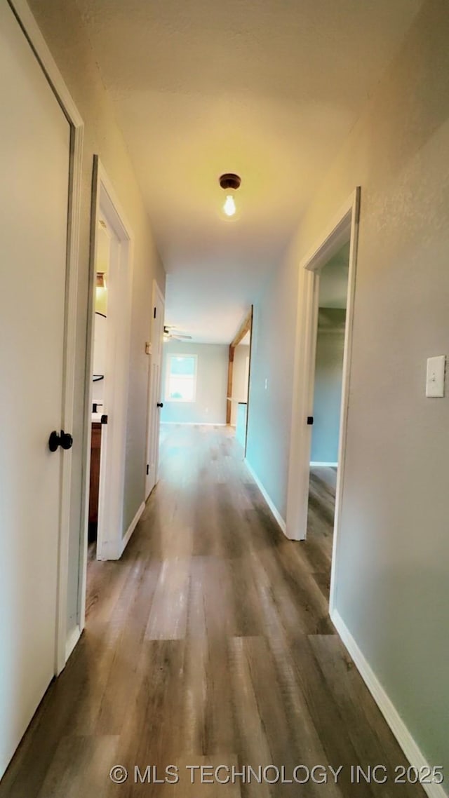 hallway with baseboards and wood finished floors