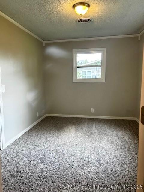 carpeted spare room with crown molding, a textured ceiling, visible vents, and baseboards