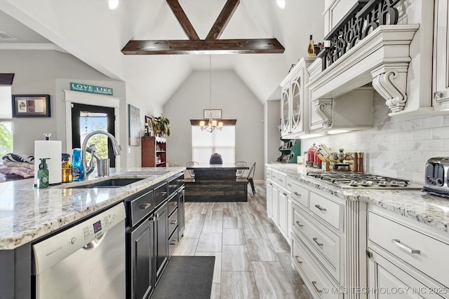kitchen with appliances with stainless steel finishes, a sink, white cabinetry, tasteful backsplash, and glass insert cabinets