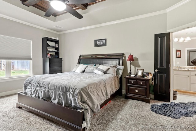 bedroom featuring crown molding, baseboards, ceiling fan with notable chandelier, carpet flooring, and ensuite bath