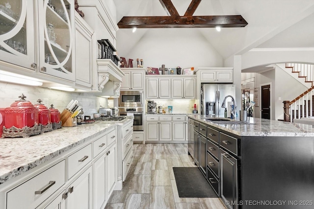 kitchen featuring glass insert cabinets, white cabinets, a sink, backsplash, and stainless steel appliances