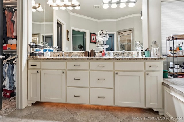 bathroom with double vanity, ornamental molding, a walk in closet, tile patterned floors, and a shower stall