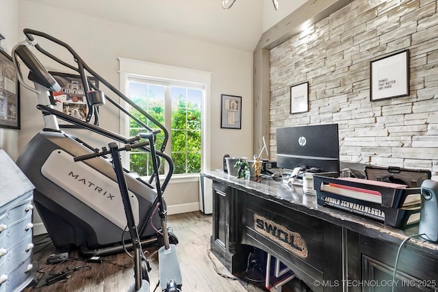 office space with baseboards, vaulted ceiling, and wood finished floors
