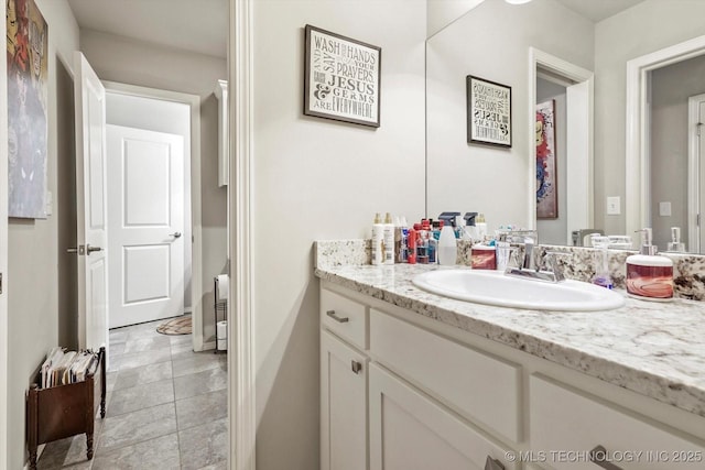 bathroom with vanity, baseboards, and stone finish floor