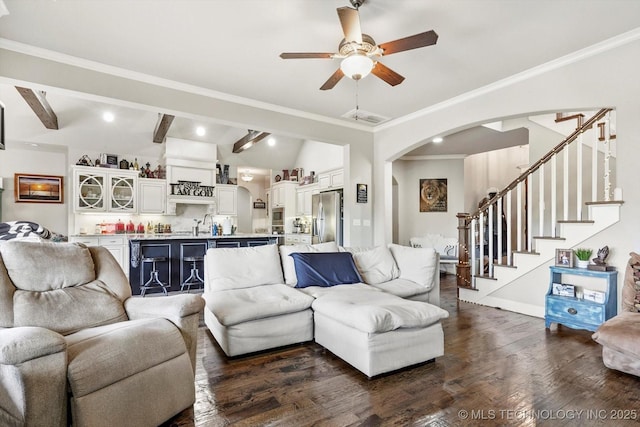 living area featuring a ceiling fan, stairs, vaulted ceiling with beams, arched walkways, and dark wood finished floors