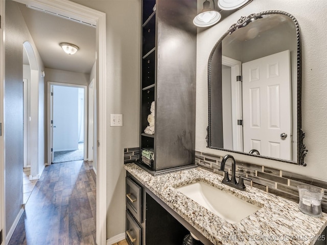 4312 N 33rd St, Broken Arrow, OK 74014 - bathroom featuring baseboards, backsplash, wood finished floors, and vanity