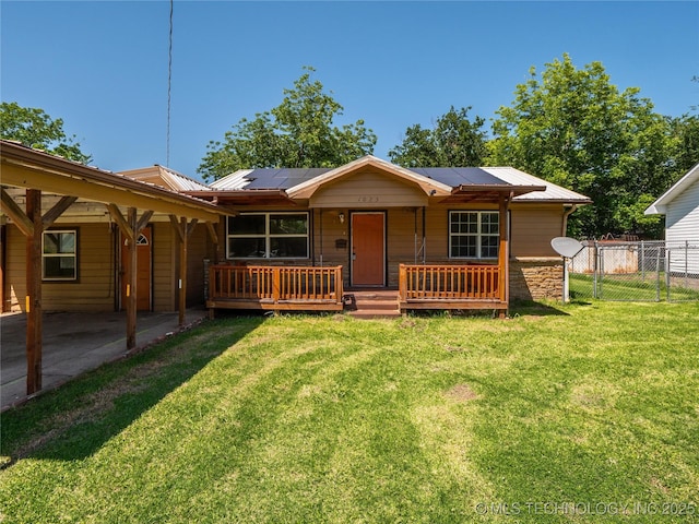 ranch-style home with fence, a front lawn, a porch, solar panels, and metal roof