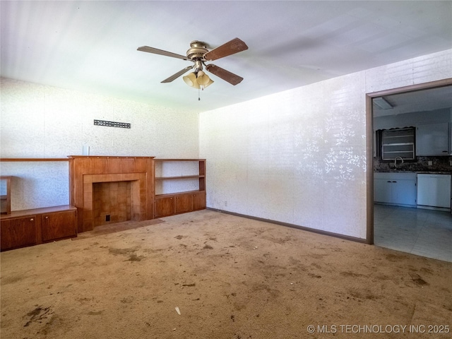 unfurnished living room with a sink, ceiling fan, and carpet flooring