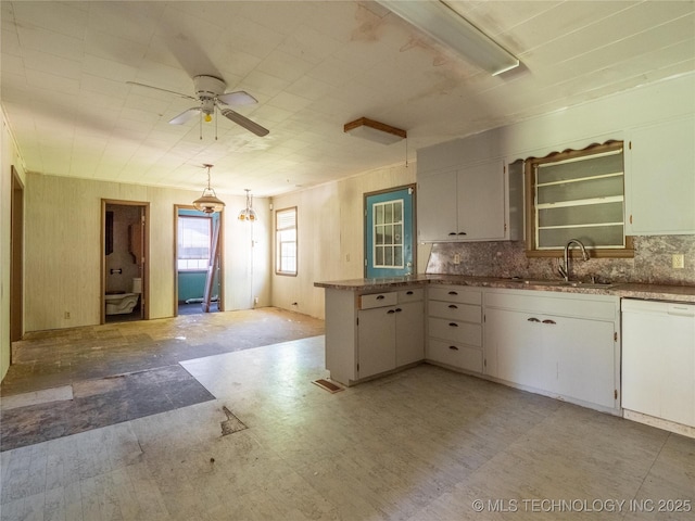 kitchen featuring ceiling fan, a sink, dishwasher, a peninsula, and light floors