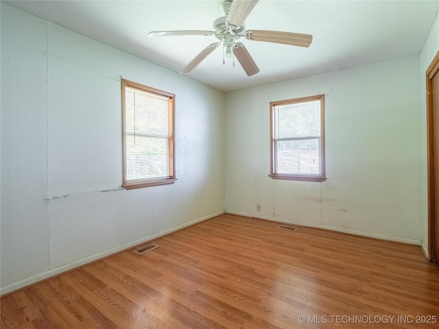 empty room featuring a ceiling fan, visible vents, and light wood-style floors