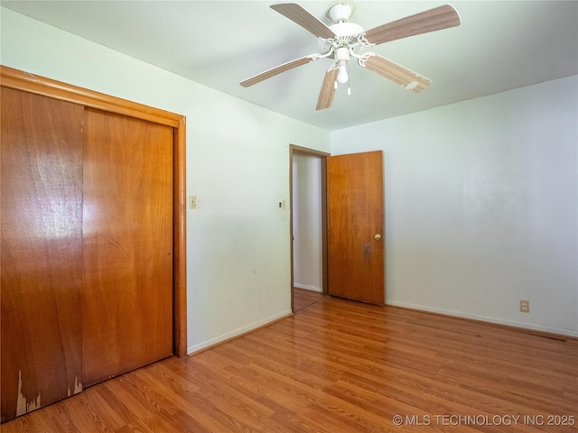 unfurnished bedroom with baseboards, ceiling fan, a closet, and wood finished floors